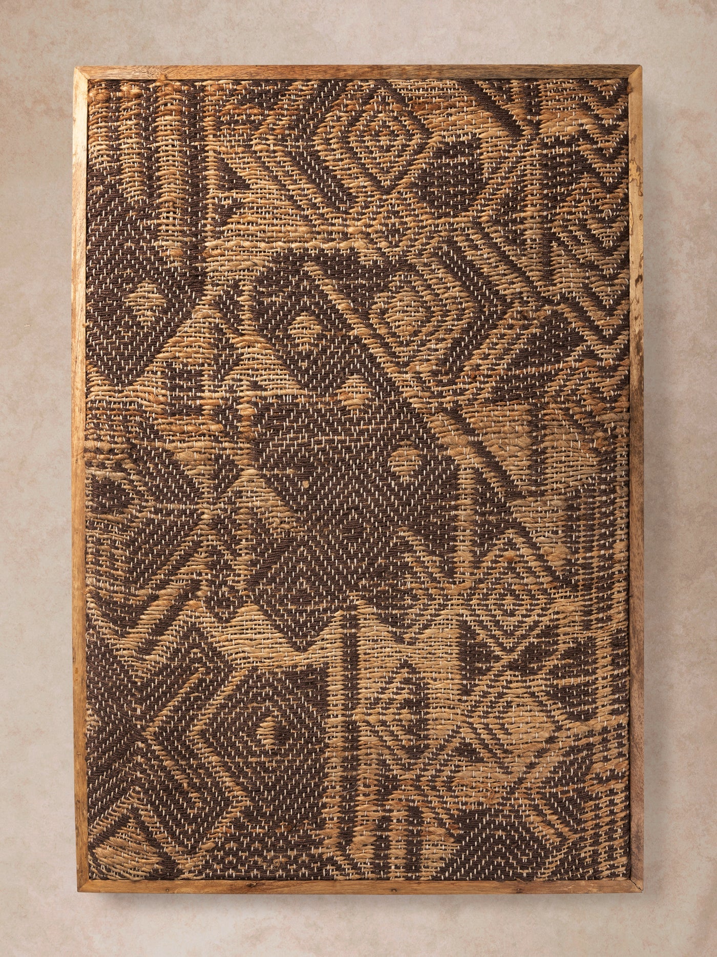 Tufted textile wall art with dense geometric pattern in earthy brown tones shown in motion, with shifting light revealing varied pile height, carved detailing, and surface depth