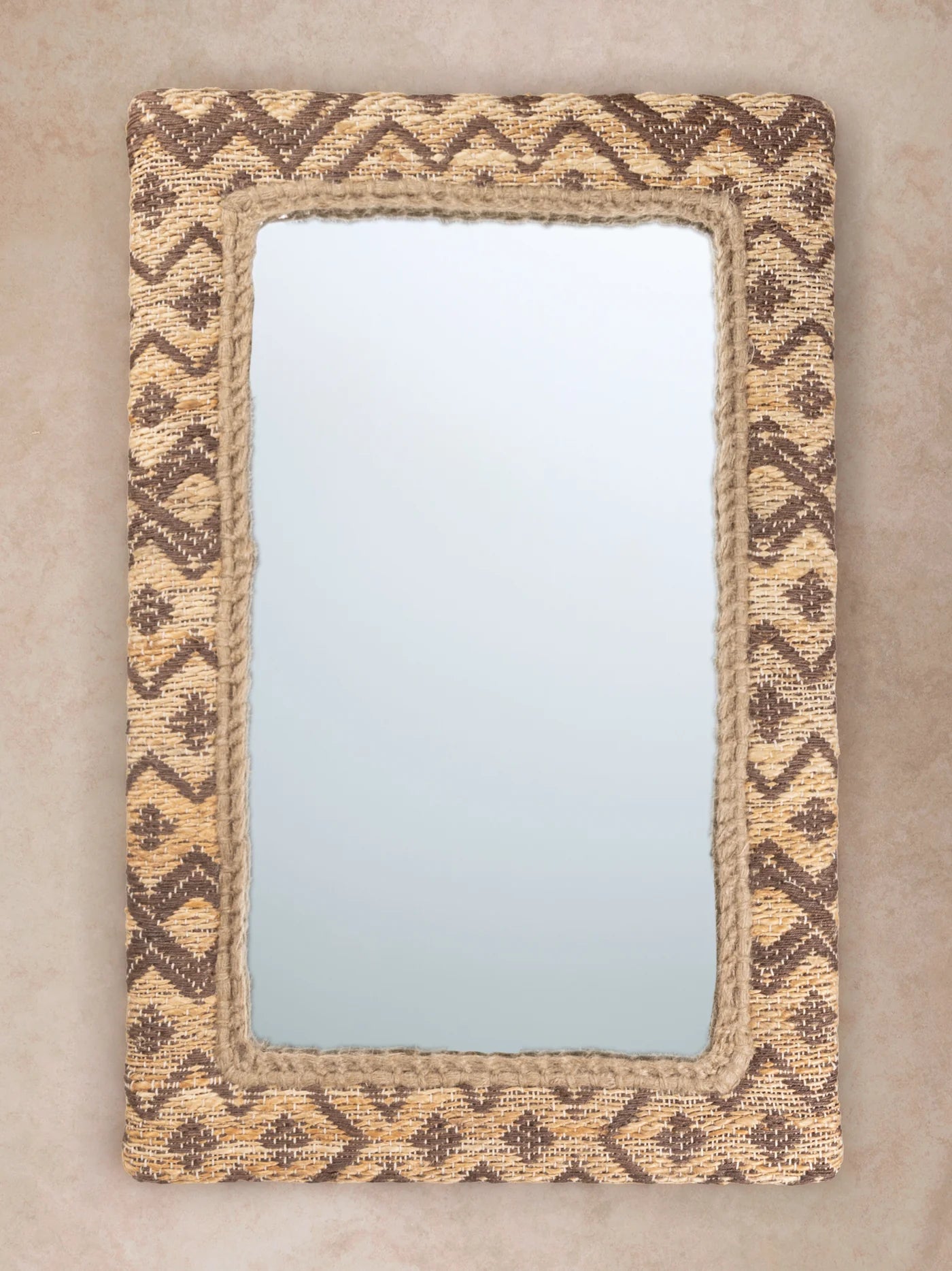 Jacquard-woven jute wall mirror with geometric pattern and braided inner border shown in motion, with shifting light revealing fiber texture, weave depth, and tonal variation