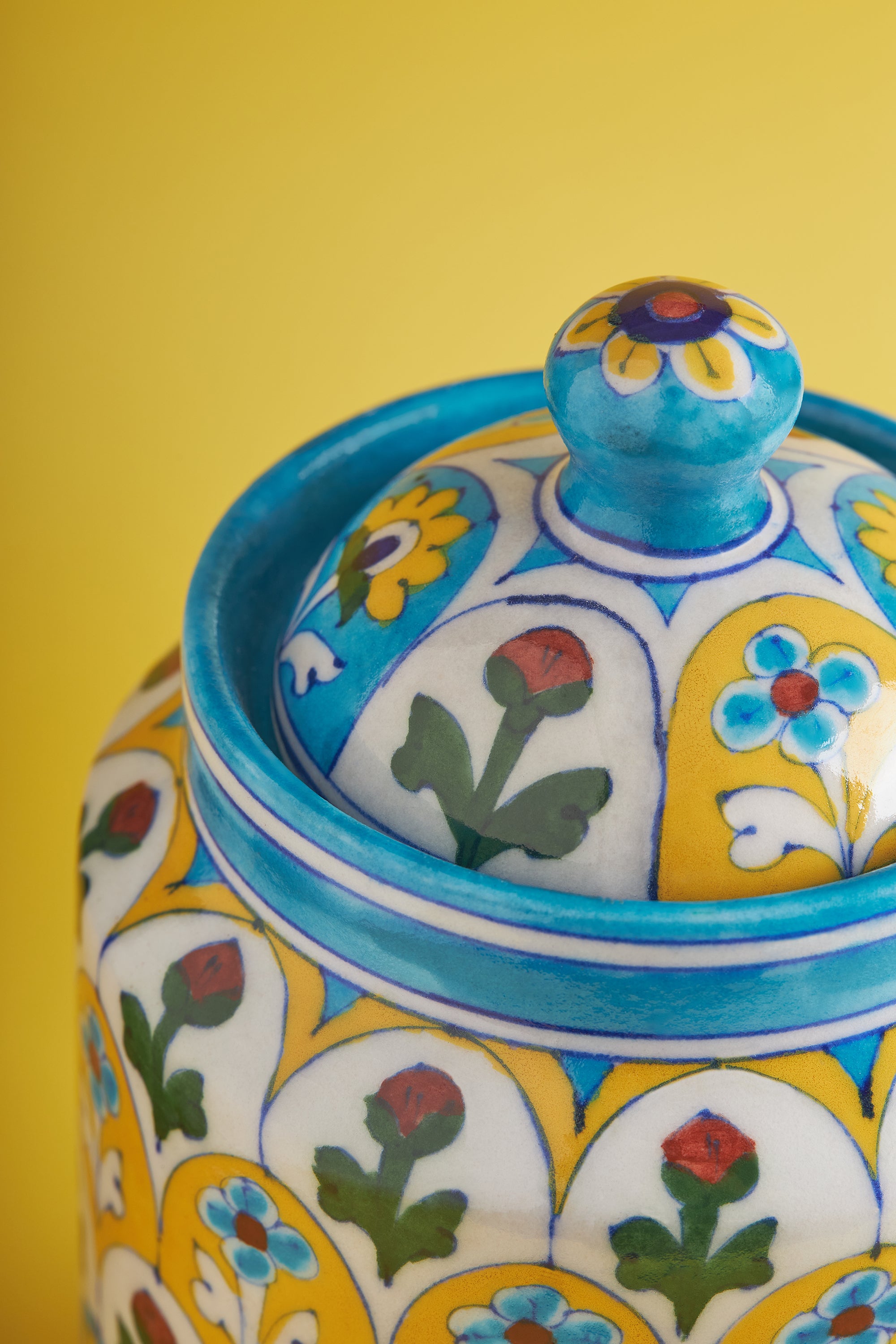 Artisan Handmade Ceramic Canister – Unique Kitchen Storage
A vibrant and functional ceramic storage jar with a lid, showcasing traditional floral designs in blue, yellow, and green hues